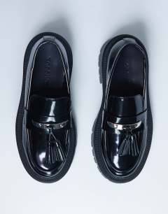 Model wearing Cameron tassel loafer with cleated sole in black