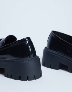 Model wearing Cameron tassel loafer with cleated sole in black