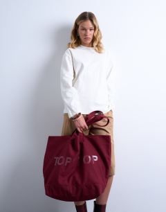 Model wearing Canvas tote bag in burgundy