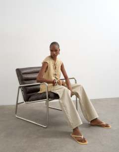 Model wearing Cap sleeve asymmetric tie front lace detail top in yellow stripe 