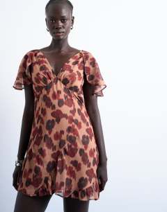 Model wearing Cape sleeve godet hem mini dress in modern print