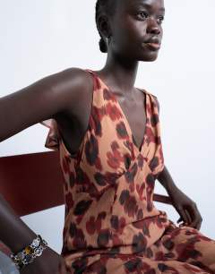 Model wearing Cape sleeve godet hem mini dress in modern print