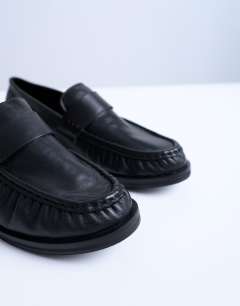 Model wearing Carey real leather loafers with ruched detail in black