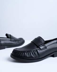 Model wearing Carey real leather loafers with ruched detail in black