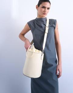 Model wearing Carla cross body bucket bag in buttermilk