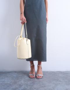Model wearing Carla cross body bucket bag in buttermilk