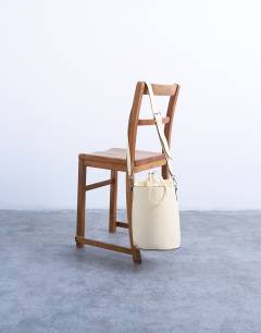 Model wearing Carla cross body bucket bag in buttermilk