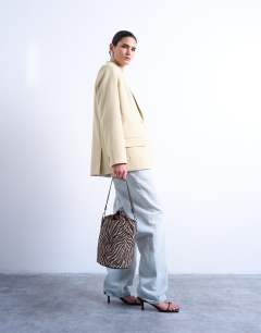 Model wearing Carla cross body canvas bucket bag in zebra