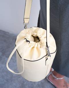 Model wearing Carla large cross body bucket bag in buttermilk