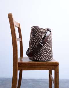 Model wearing Carla large cross body canvas bucket bag in zebra