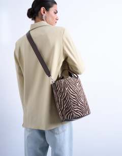 Model wearing Carla large cross body canvas bucket bag in zebra