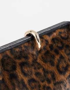 Model wearing Carlie faux fur medium clutch with hardware in leopard print