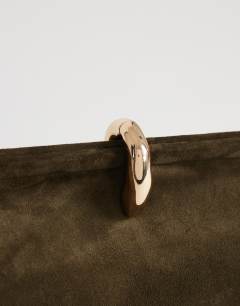 Model wearing Carlie medium clutch with hardware in khaki