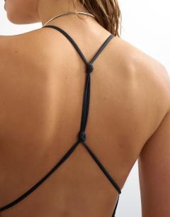 Model wearing Carlie swimsuit with twisted back detail in black