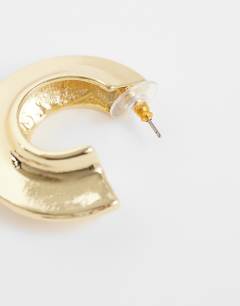 Model wearing Cassie chunky hoop earrings in gold tone