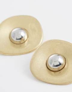 Model wearing Cece statement round stud earrings in gold tone