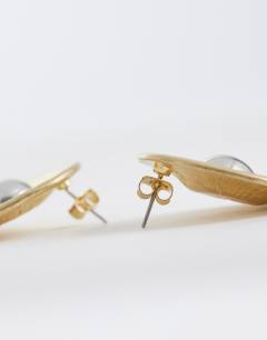 Model wearing Cece statement round stud earrings in gold tone