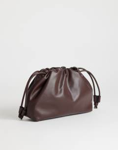 Model wearing Celia medium ruched clutch bag in chocolate