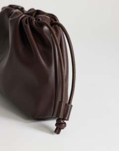 Model wearing Celia medium ruched clutch bag in chocolate