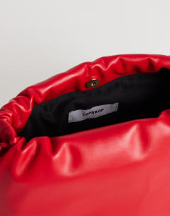Model wearing Celia medium ruched clutch bag in red