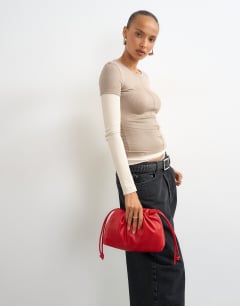 Model wearing Celia medium ruched clutch bag in red