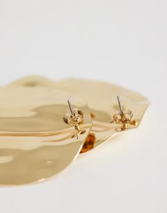 Model wearing Chantal large statement disc earrings in gold tone