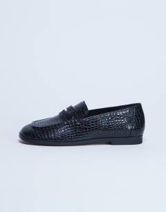 Model wearing Charlie flat loafer in black lizard