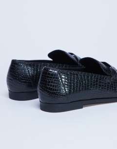 Model wearing Charlie flat loafer in black lizard