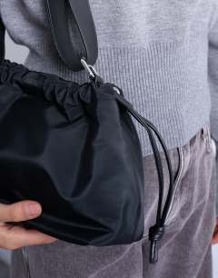 Model wearing Charlie medium nylon cross body bag in black