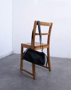 Model wearing Charlie medium nylon cross body bag in black