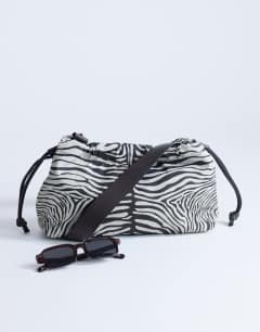 Model wearing Charlie medium nylon cross body bag in zebra