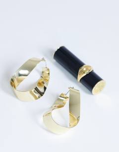 Model wearing Charlotte twisted hoop earring in gold tone