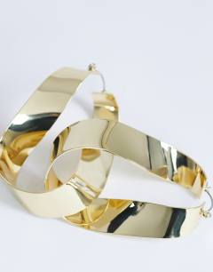 Model wearing Charlotte twisted hoop earring in gold tone