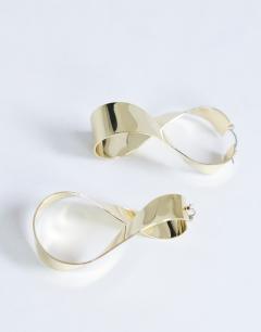 Model wearing Charlotte twisted hoop earring in gold tone