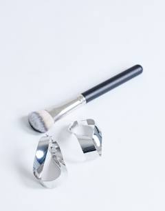 Model wearing Charlotte twisted hoop earring in silver tone