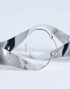 Model wearing Charlotte twisted hoop earring in silver tone