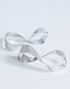 Model wearing Charlotte twisted hoop earring in silver tone