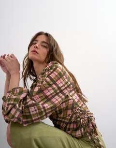 Model wearing Check print long sleeve ruched side top in multi