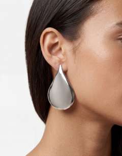 Model wearing Cher statement teardrop stud earrings in silver tone