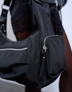 Model wearing Cheryl large nylon crossbody bag in black