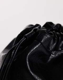 Model wearing Chloe oversized ruched pouch clutch bag in black