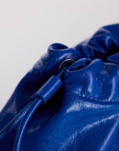 Model wearing Chloe oversized ruched pouch clutch bag in cobalt
