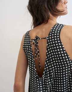 Model wearing Chuck on boxy playsuit in mono check