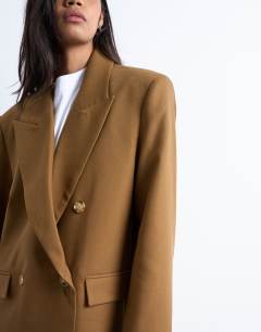 Model wearing Chuck on tailored 6 button formal coat in tan