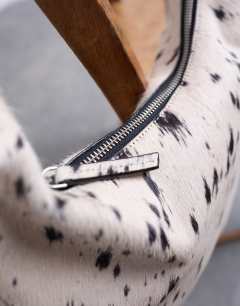 Model wearing Cian real suede scoop grab bag in dalmatian