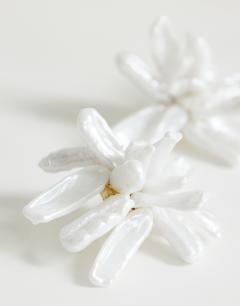Model wearing Ciara statement pearl flower earrings in white and gold