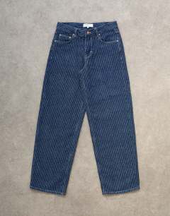 Model wearing Cinch low rise jean in textured stripe detail indigo rinse
