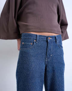 Model wearing Cinch low rise jean in tufted detail indigo rinse stripe