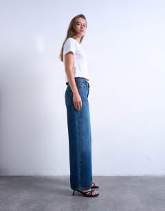 Model wearing Cinch low rise jeans in dark stone wash