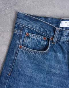 Model wearing Cinch low rise jeans in dark stone wash